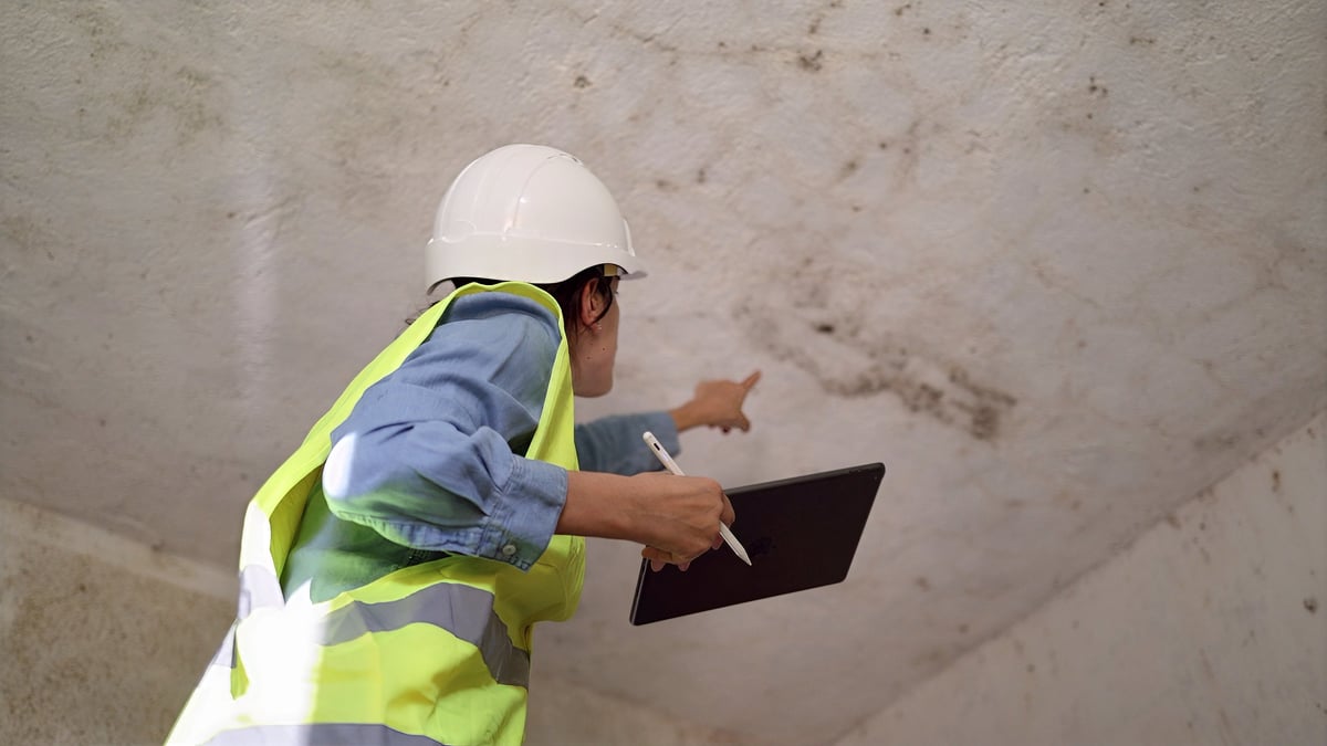 Inspector reviewing structural damage inside a building during a foundation and safety assessment